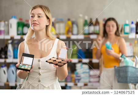 customer chooses cosmetics in a supermarket against the background of a visitor customer chooses cosmetics in a supermarket against the background of a visitor 124067525