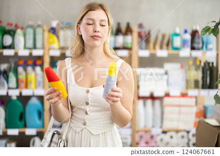 Young girl choosing insect repellent in supermarket 124067661