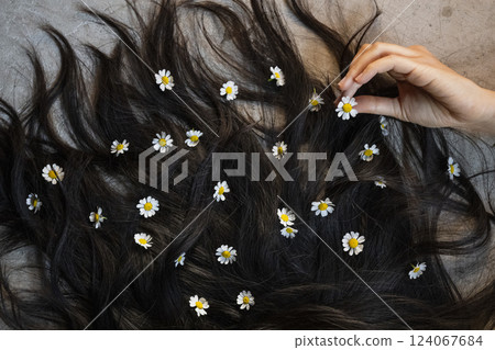 Woman black hair decorated with daisy flowers Woman black hair decorated with daisy flowers 124067684