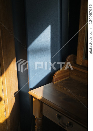 Sunlight casting a shadow on a blue wall 124067686