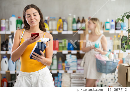 Young woman scanning qr code for cleaning spray 124067742
