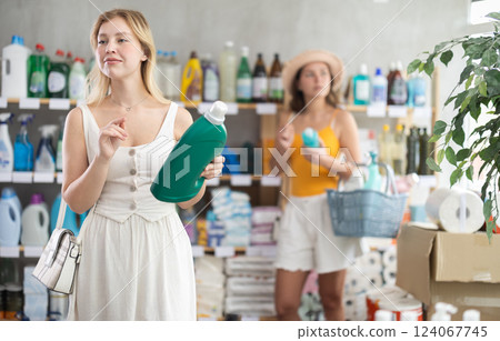 Young female customer choosing fabric softener in busy supermarket 124067745