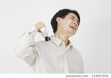 Man in his 20s using a massage gun, white background Man in his 20s using a massage gun, white background 124067950