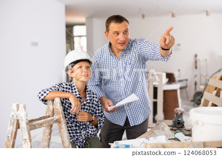 Father and son talking about space planning in new apartment 124068053