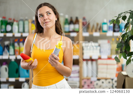 Young woman choosing repellent in supermarket Young woman choosing repellent in supermarket 124068130