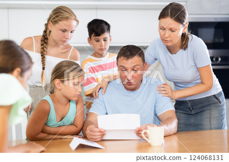 Big family reading upset letter 124068131