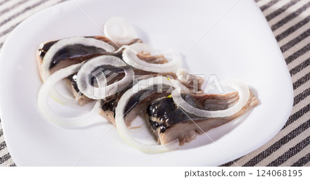 Sliced salted herring with onion 124068195