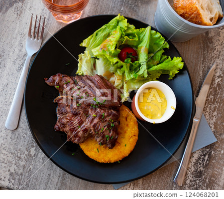 French traditional dish. Fried beef with salad of vegetables and herbs French traditional dish. Fried beef with salad of vegetables and herbs 124068201