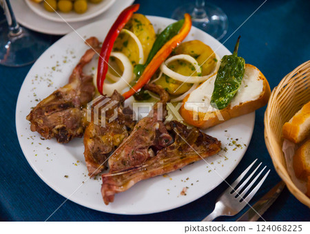 Baked under tasty lamb served with potatoes and bread Baked under tasty lamb served with potatoes and bread 124068225