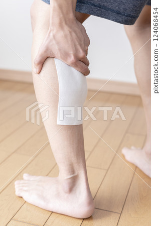 Applying a compress to the calf, compress, muscle pain, body parts 124068454