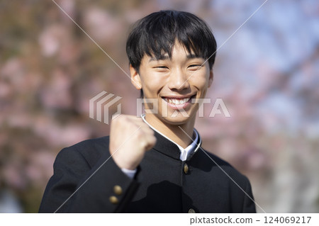 A high school boy standing in front of the cherry blossoms A high school boy standing in front of the cherry blossoms 124069217
