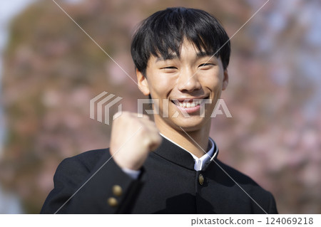 A high school boy standing in front of the cherry blossoms A high school boy standing in front of the cherry blossoms 124069218