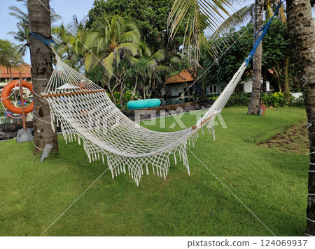 Tropical summer landscape with hammock and green trees. Paradise island beach vacation or summer holiday destination Tropical summer landscape with hammock and green trees. Paradise island beach vacation or summer holiday destination 124069937