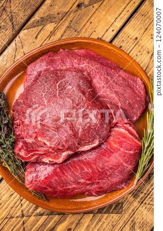 Traditional German beef cheeks, raw meat in plate. wooden background. top view Traditional German beef cheeks, raw meat in plate. wooden background. top view 124070007