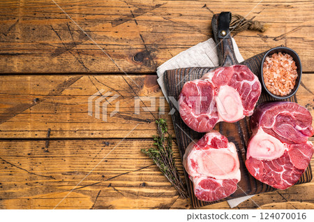 Fresh raw ossobuco, osso buco meat, showcasing tender veal shank with rich marrow, perfect for gourmet Italian dishes. wooden background. top view Fresh raw ossobuco, osso buco meat, showcasing tender veal shank with rich marrow, perfect for gourmet Italian dishes. wooden background. top view 124070016