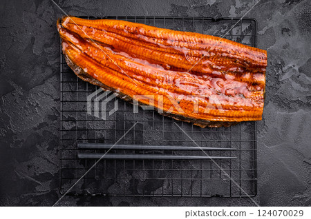 Japanese unagi eel, grilled fish fillet of eel. black background. top view Japanese unagi eel, grilled fish fillet of eel. black background. top view 124070029