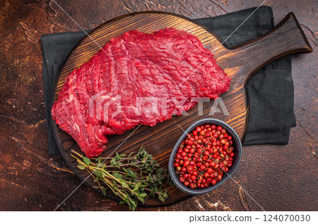 Flank or Flap steak, raw beef meat with thyme on wooden board. brown background. top view Flank or Flap steak, raw beef meat with thyme on wooden board. brown background. top view 124070030