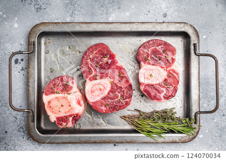Raw ossobuco cuts, veal shank meat, the ultimate ingredient for rich stews and classic Italian comfort food delights. grey background. top view Raw ossobuco cuts, veal shank meat, the ultimate ingredient for rich stews and classic Italian comfort food delights. grey background. top view 124070034