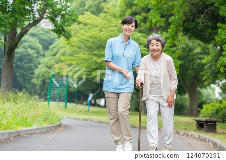 Senior woman and caregiver taking a walk 124070191