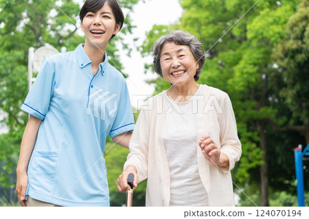 Senior woman and caregiver taking a walk 124070194