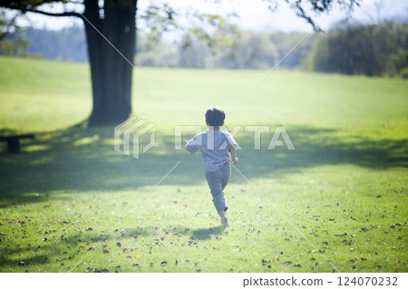 Boy running barefoot, back view Boy running barefoot, back view 124070232