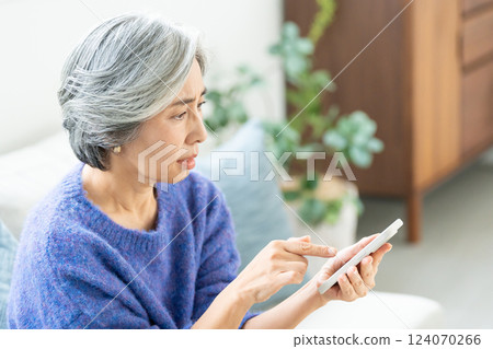 操作智能手機的資深婦女 124070266