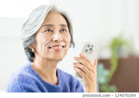 操作智能手機的資深婦女 124070269