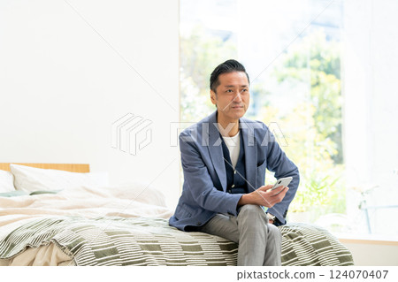 Middle man looking at a smartphone in bed 124070407