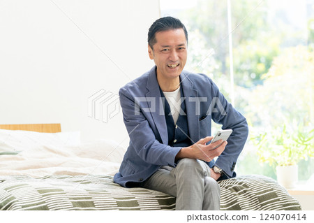 中間人在床上看智能手機 124070414