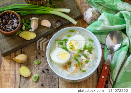 Hot soup chicken with ginger rice and garlic in a bowl on a rustic table. 124072260