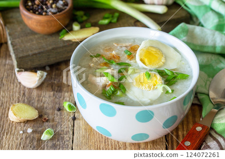 Hot soup chicken with ginger rice and garlic in a bowl on a rustic table. Hot soup chicken with ginger rice and garlic in a bowl on a rustic table. 124072261