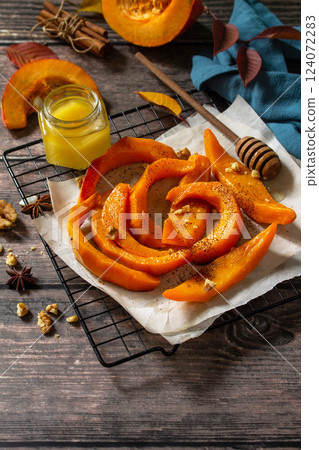 Pumpkin dessert. Baked pumpkin slices with honey, cinnamon and walnuts on a rustic table. Copy space. Pumpkin dessert. Baked pumpkin slices with honey, cinnamon and walnuts on a rustic table. Copy space. 124072283