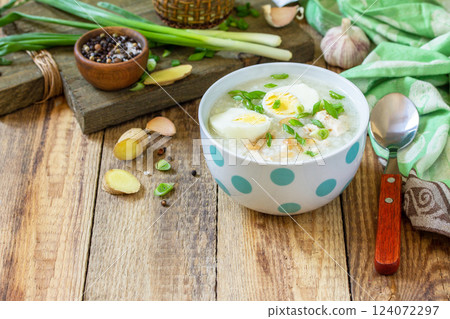 Hot soup chicken with ginger rice and garlic in a bowl on a rustic table. Copy space. Hot soup chicken with ginger rice and garlic in a bowl on a rustic table. Copy space. 124072297