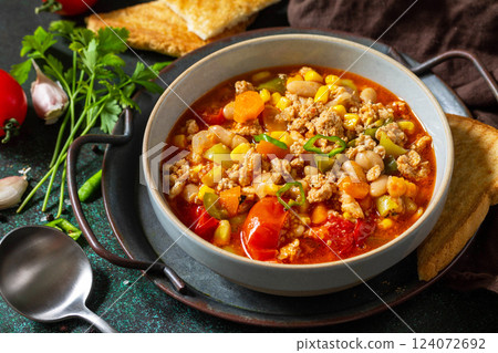 Traditional mexican food. Chili con carne, minced meat with vegetables on dark stone table. Traditional mexican food. Chili con carne, minced meat with vegetables on dark stone table. 124072692