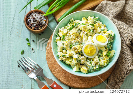 Spring salad with egg, green peas and green onions in a bowl on a rustic table. Copy space. 124072712