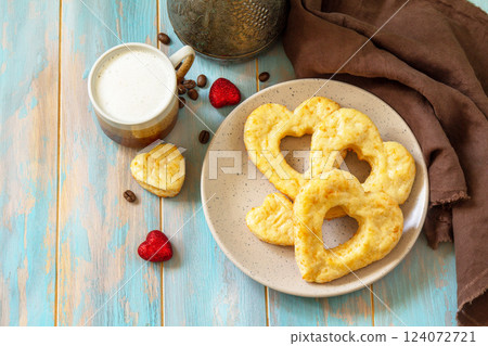 Breakfast for valentine's day or mother's day concept. Curd cheese pastries and a cup of cappuccino coffee on a rustic table. 124072721