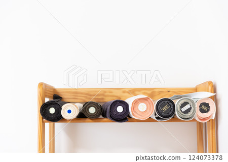 Rolls of obi cloth lined up on a shelf 124073378