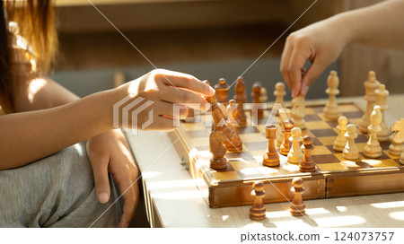 Close up shot of two players playing chess in a sunlit room 124073757