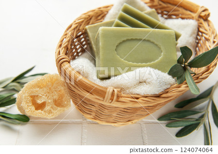 Olive soap bars resting on soft towel in wicker basket, embracing natural hygiene 124074064