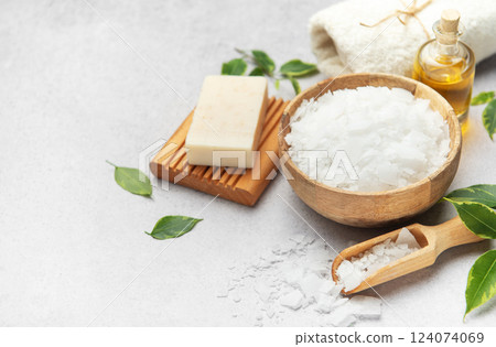 Magnesium flakes in a wooden bowl with soap, towel and essential oil creating a relaxing spa scene Magnesium flakes in a wooden bowl with soap, towel and essential oil creating a relaxing spa scene 124074069
