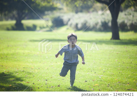 男孩在草地上奔跑 男孩在草地上奔跑 124074421