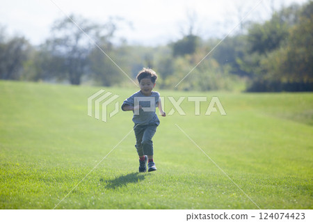 Boy running on the grass 124074423