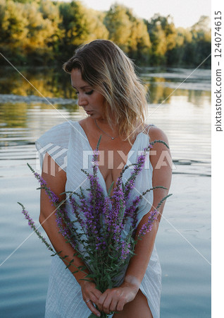 Woman Holding Flowers by a Serene Lake Scene 124074615