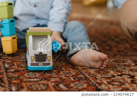 Child Playing with Toy Truck on Carpet 124074617