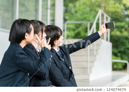 國中和高中女生在學校走廊上用智慧型手機自拍(放學後、回家、朋友) 國中和高中女生在學校走廊上用智慧型手機自拍(放學後、回家、朋友) 124074679