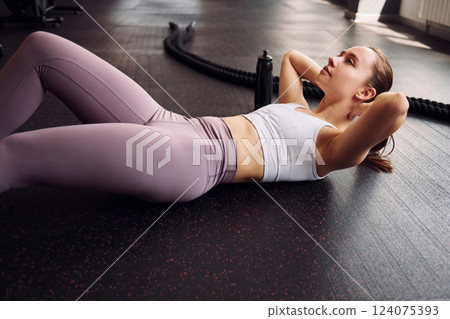Doing abs. Young beautiful woman in sportive clothes have fitness day in the gym 124075393