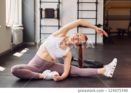 Yoga exercises and streching. Young beautiful woman in sportive clothes have fitness day in the gym Yoga exercises and streching. Young beautiful woman in sportive clothes have fitness day in the gym 124075396