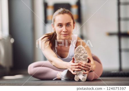 Yoga exercises and streching. Young beautiful woman in sportive clothes have fitness day in the gym Yoga exercises and streching. Young beautiful woman in sportive clothes have fitness day in the gym 124075397
