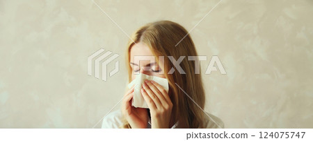 Sick exhausted young woman sneezing blow nose using tissue, unhealthy suffering girl feels unwell 124075747