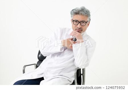 A man in a white coat sitting on a chair A man in a white coat sitting on a chair 124075932